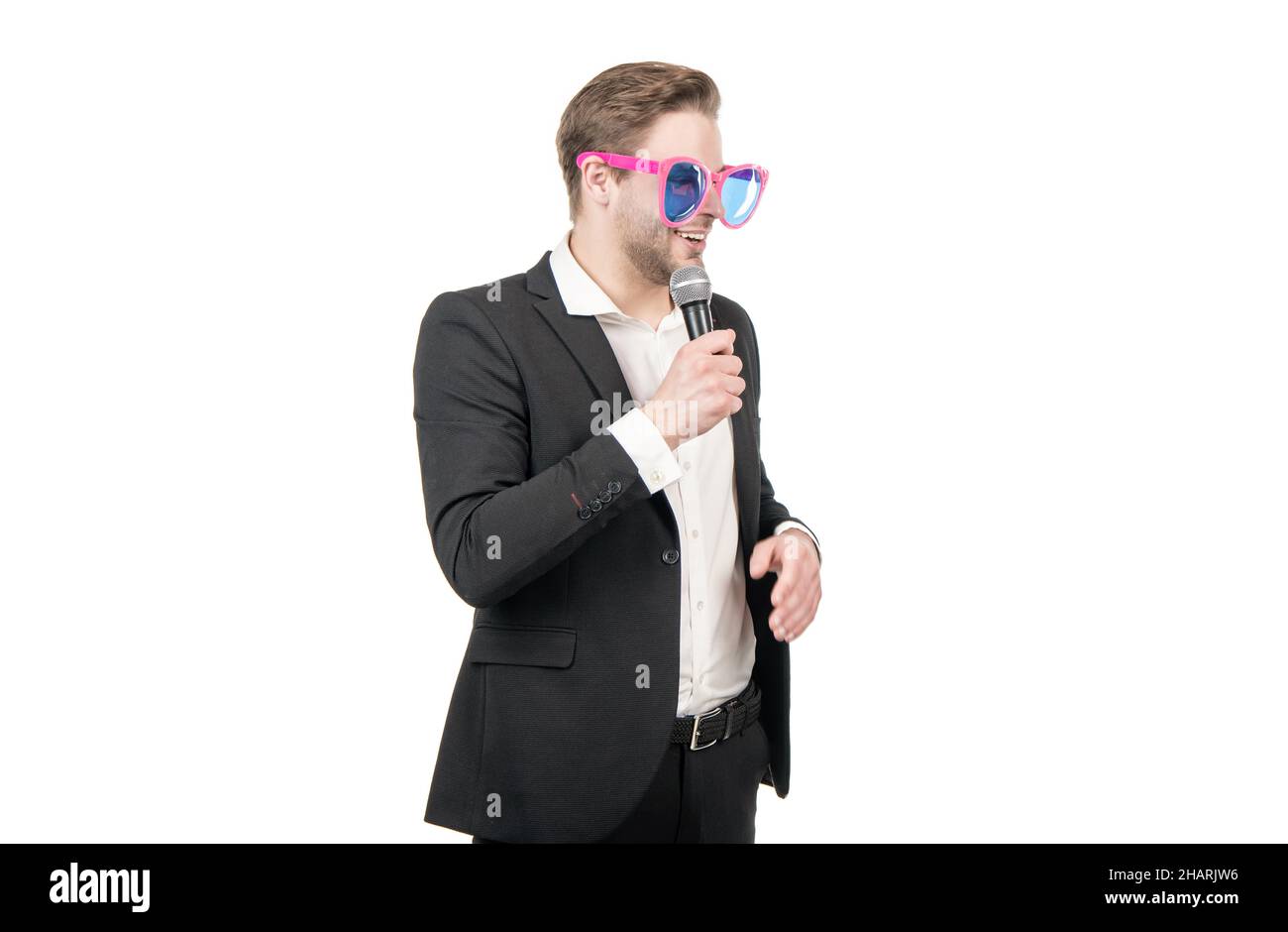 Hombre profesional showman en gafas divertidas hablar con micrófono aislado en blanco, altavoz Foto de stock