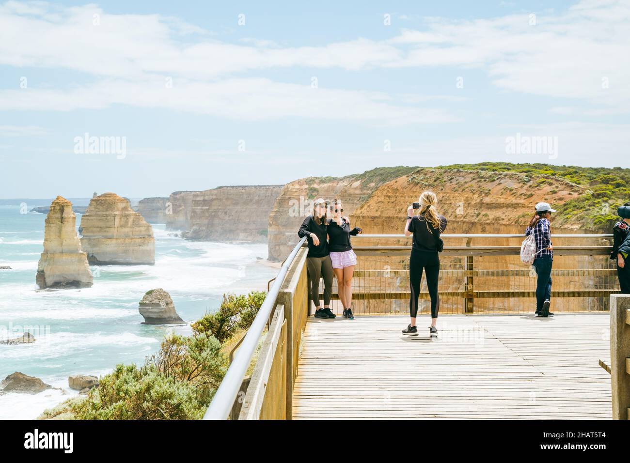 Port Campbell, Victoria Australia - 11 de diciembre de 2021 - Amigos fotografiándose unos a otros en el destino turístico de 12 Apóstoles en la Gran Carretera Oceánica Foto de stock