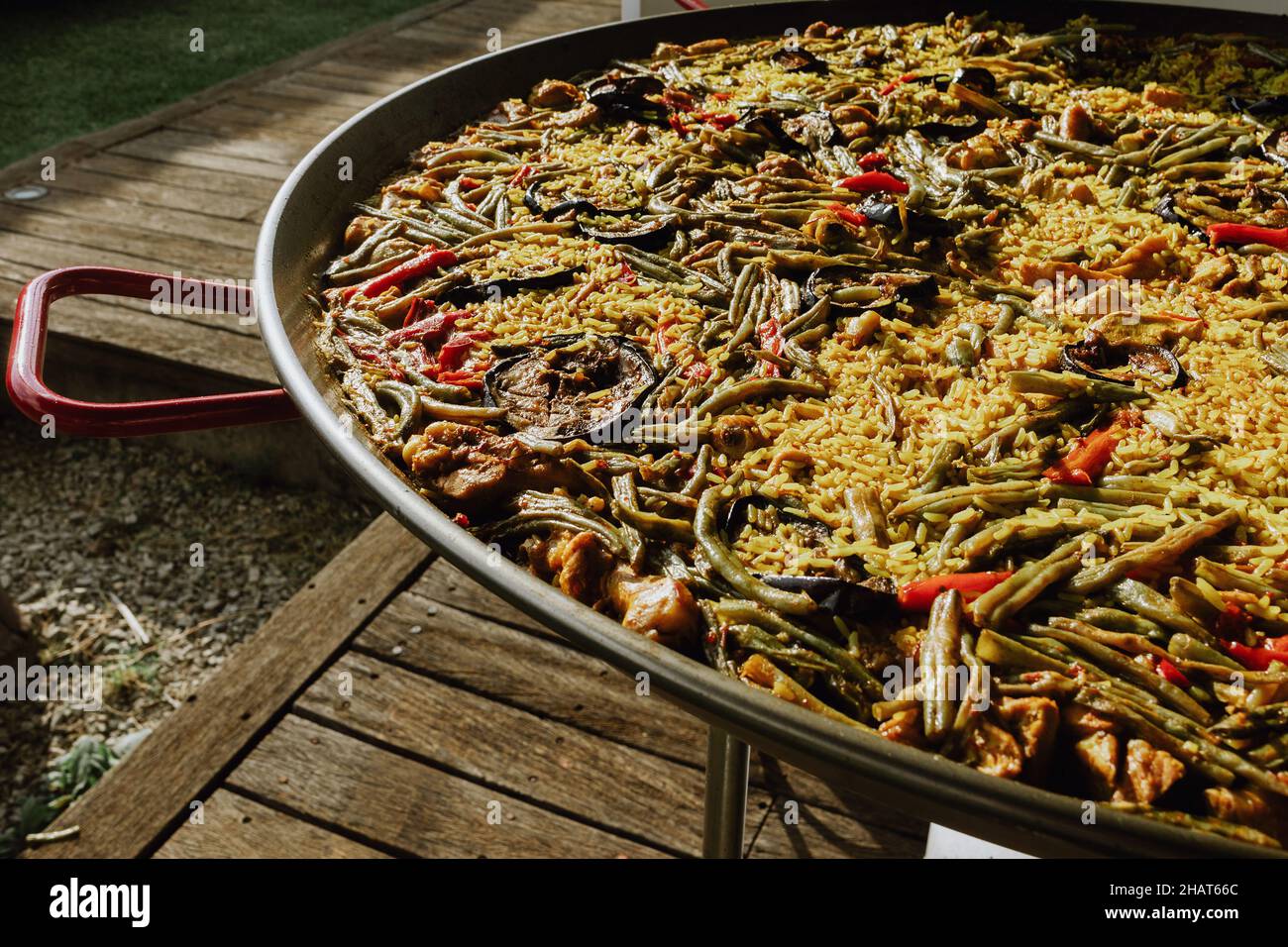 Proceso de preparación de paella en una sartén con pollo y verduras y  condimentos a mano del chef y cocina en una terraza en España Fotografía de  stock - Alamy