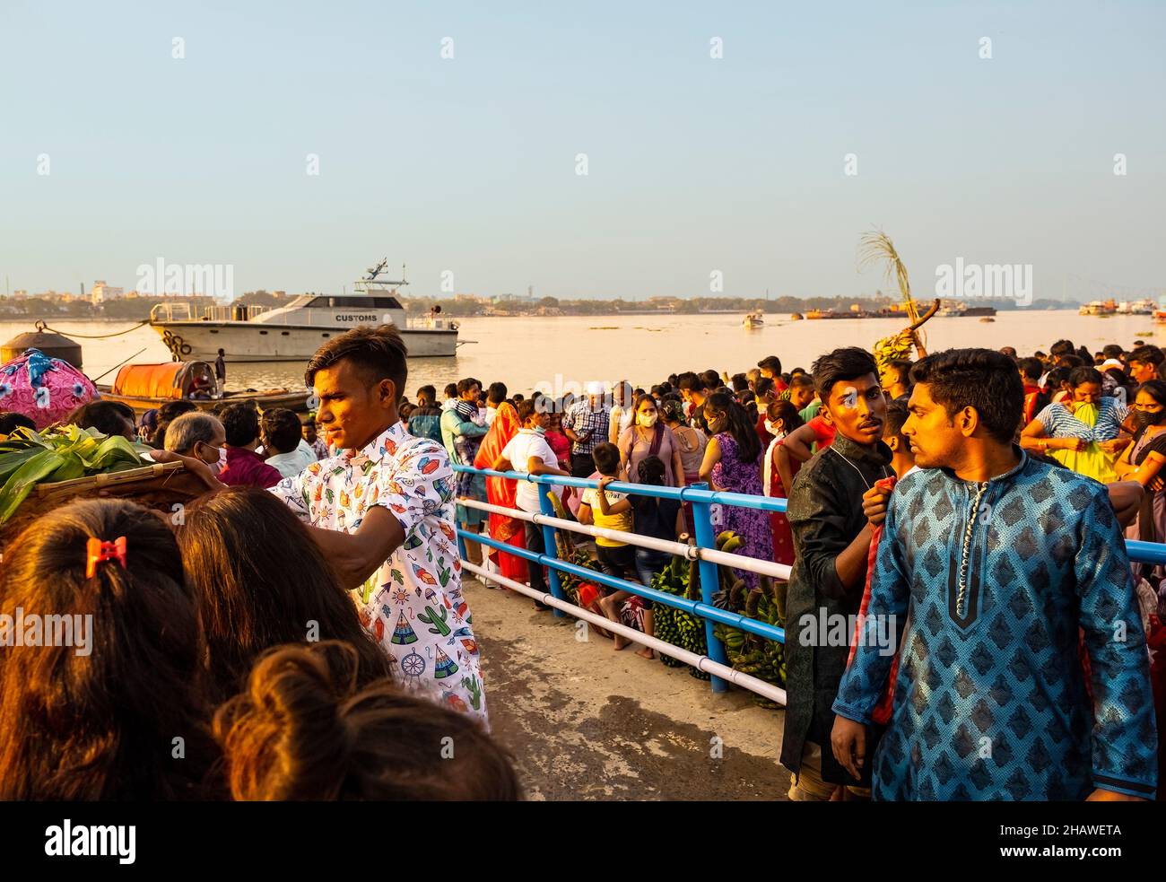 Enorme conegración, de devotos, en el río Ganga, para tener un vistazo, de entorno, sol, como, inicio del ritual, de Chhat Puja, por, pueblo Bihar, Kolkata, India Foto de stock