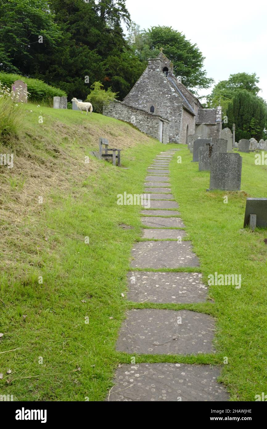 Iglesia de San Issui y cementerio con camino de piedra, Partrishow, Powys, Gales Foto de stock