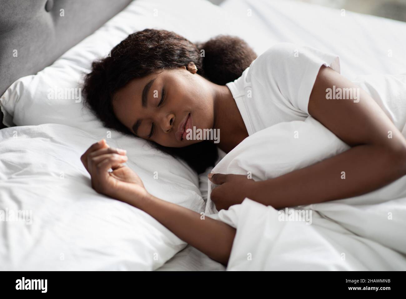 Retrato de primer plano de una mujer negra joven durmiendo en la cama Foto de stock