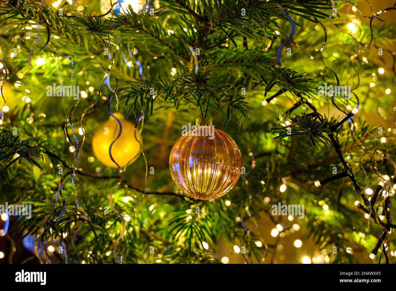 Décorations de Noël sur un sapin, boules et guirlandes lumineuse. Adornos navideños en un árbol, bolas y luces. Foto de stock