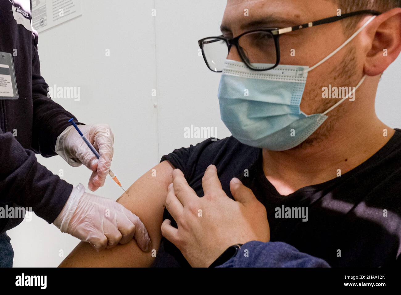 un niño recibe su tercera dosis de vacuna hoy 15 de diciembre de 2021 en italia, la tercera dosis de vacunación es obligatoria para el personal escolar y los agentes del orden público Foto de stock