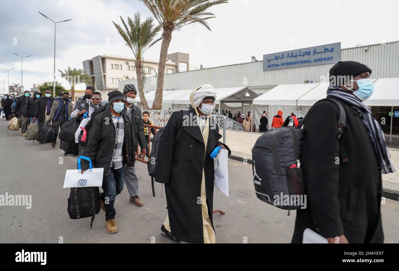 Trípoli, Libia. 15th de Dic de 2021. Los inmigrantes caminan en el Aeropuerto Internacional de Mitiga en Trípoli, Libia, 15 de diciembre de 2021. Un total de 138 inmigrantes ilegales fueron deportados voluntariamente de Libia a Sudán el miércoles. Crédito: Hamza Turkia/Xinhua/Alamy Live News Foto de stock