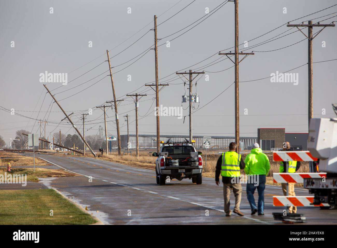 Los trabajadores de servicios públicos evalúan los daños a las líneas eléctricas en Kearney, Nebraska, el 15 de diciembre de 2021, después de que una tormenta eléctrica severa soplara a través de la ciudad. Foto de stock