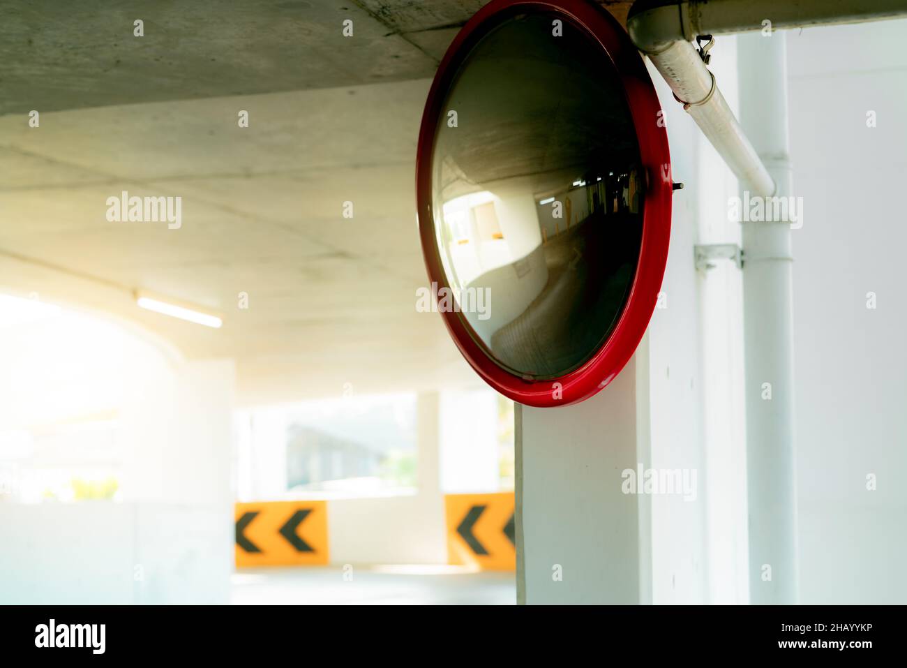 Espejo de seguridad convexo en la curva del aparcamiento interior para reducir el riesgo de accidentes por ángulos muertos o puntos ciegos. Espejo de seguridad circular convexo Foto de stock