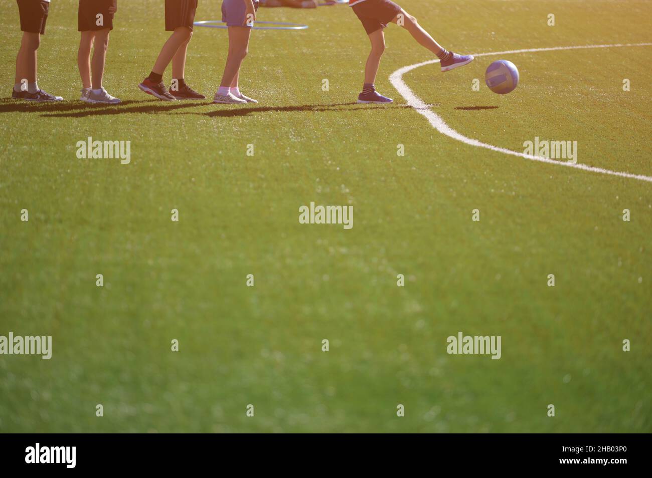 grupo de entrenamiento de fútbol y fútbol para niños pateando pelota en el campo verde Foto de stock