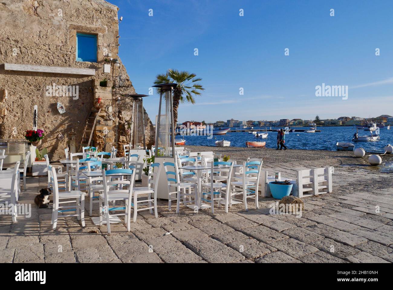 Encantadora zona de estar al aire libre con preciosas vistas al mar y a los barcos de pesca. Marzamemi, Provincia de Siracusa, Sicilia. Foto de stock