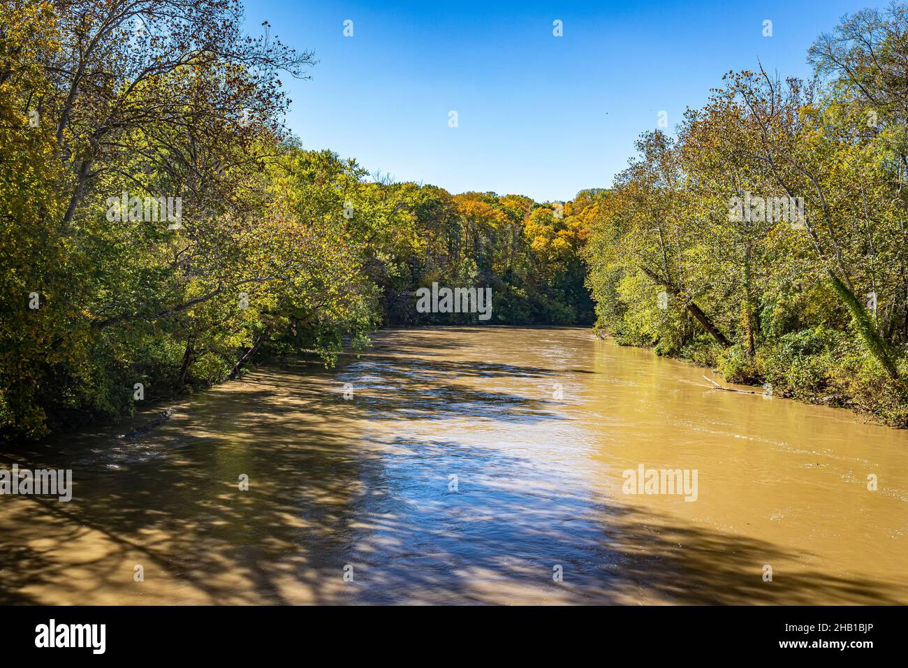 El exceso de agua después de fuertes lluvias se acerca a las orillas de Sugar Creek cerca de Annapolis en el Condado de Parke, Indiana, durante el cambio de color de las hojas de otoño. Foto de stock