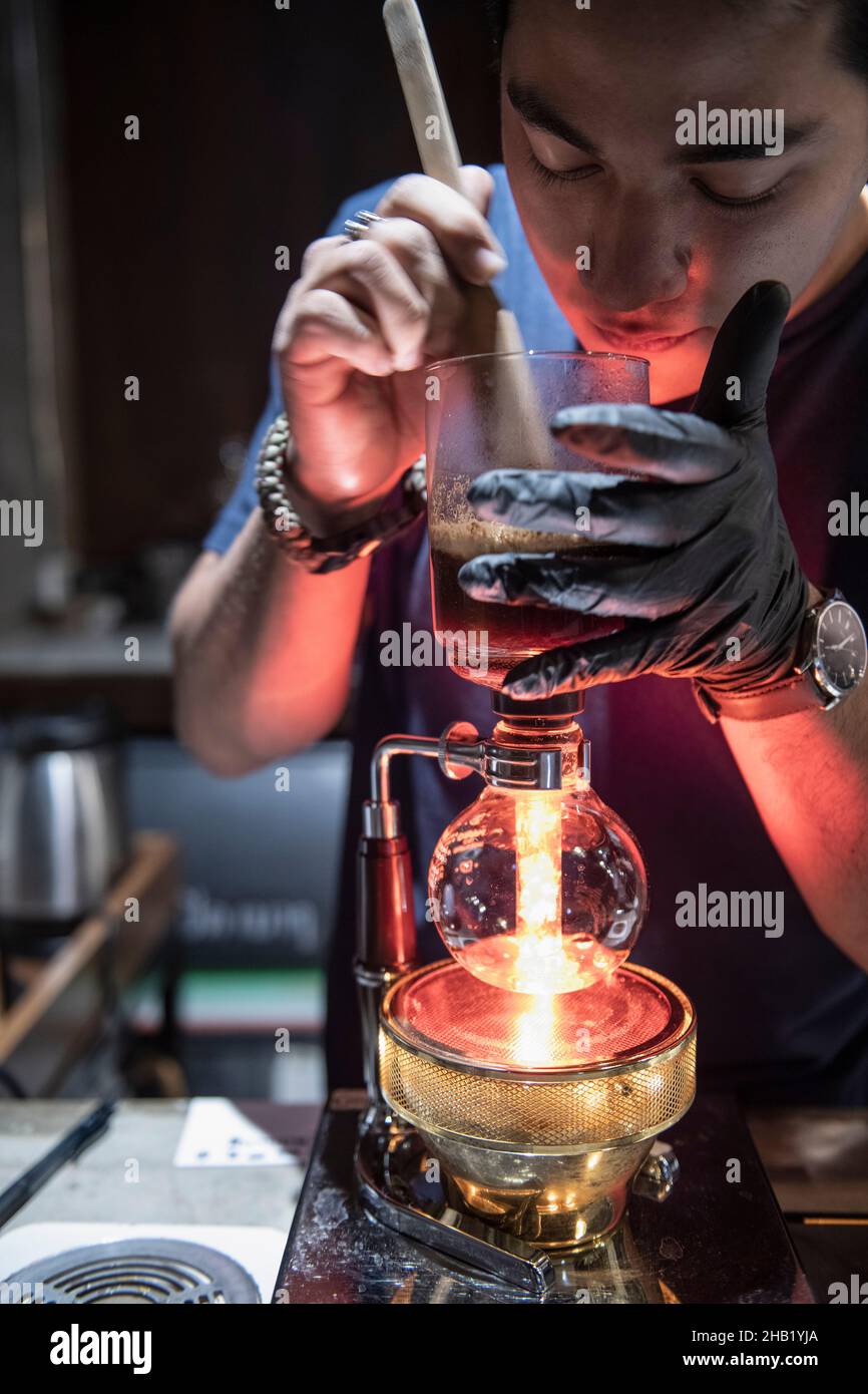 Barista está usando una cafetera siphon en el café hipster en Bangkok Foto de stock