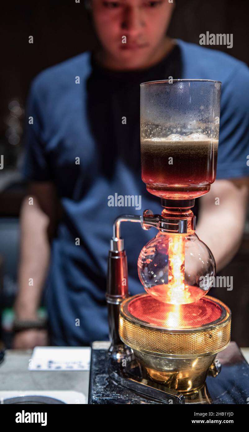 Barista está usando una cafetera siphon en el café hipster en Bangkok Foto de stock