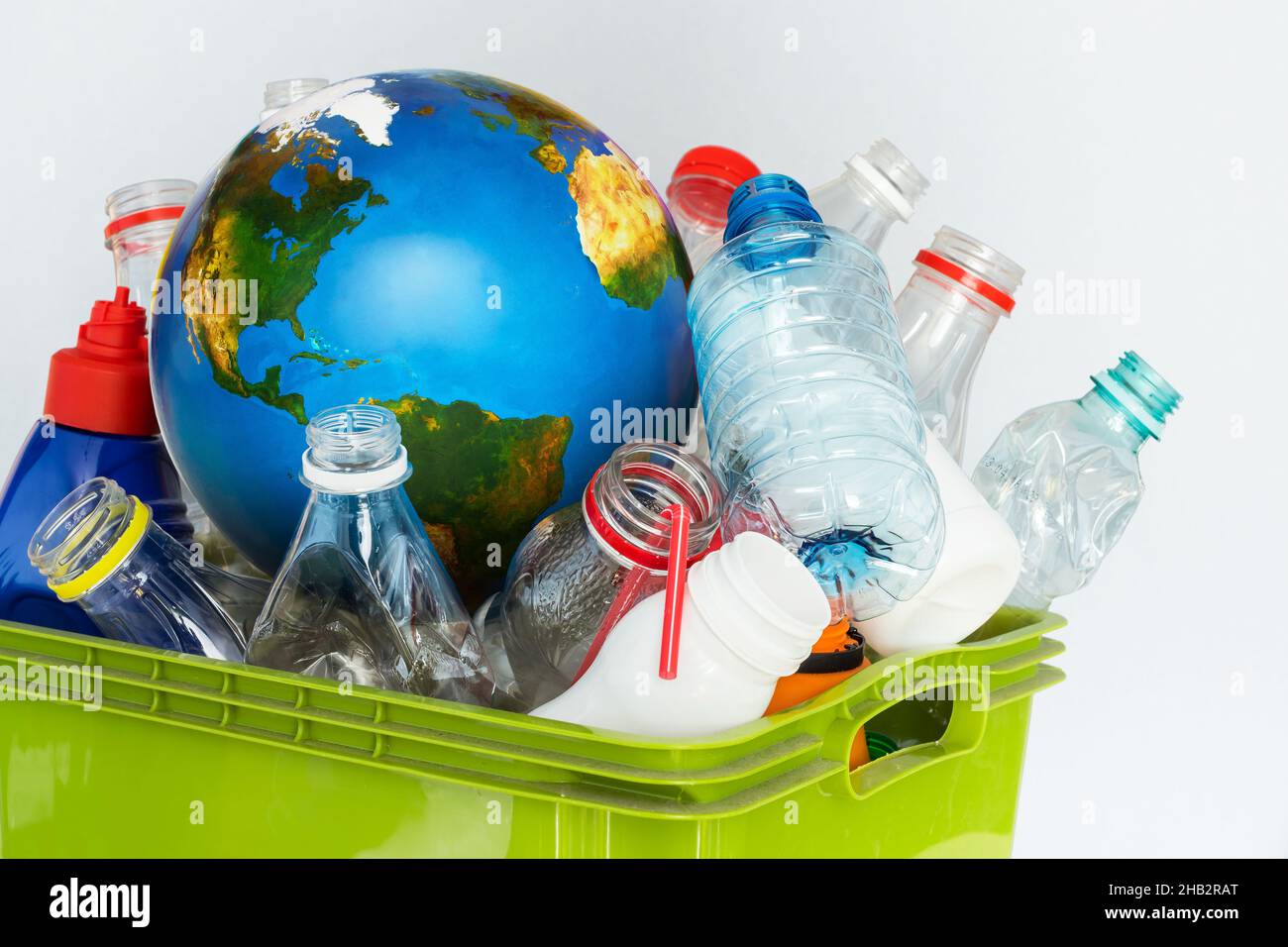 Los residuos plásticos clasificados y un globo terráqueo como símbolo de la contaminación global del plástico. Concepto de reciclaje Foto de stock
