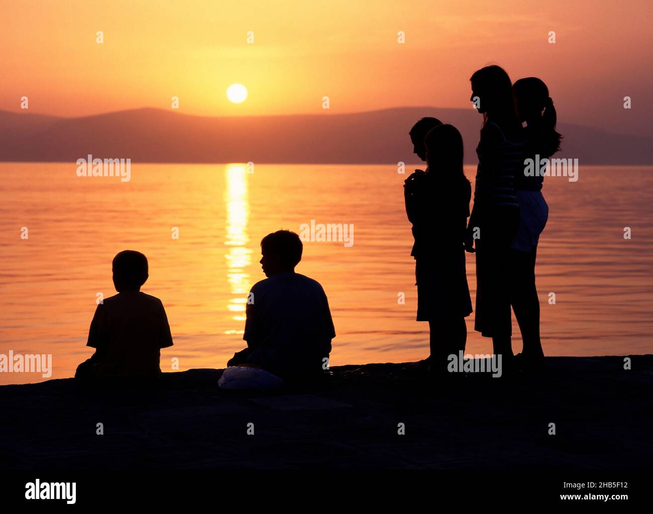 Gente Silhouette en Sunset on the Croation Coast, Croacia Foto de stock