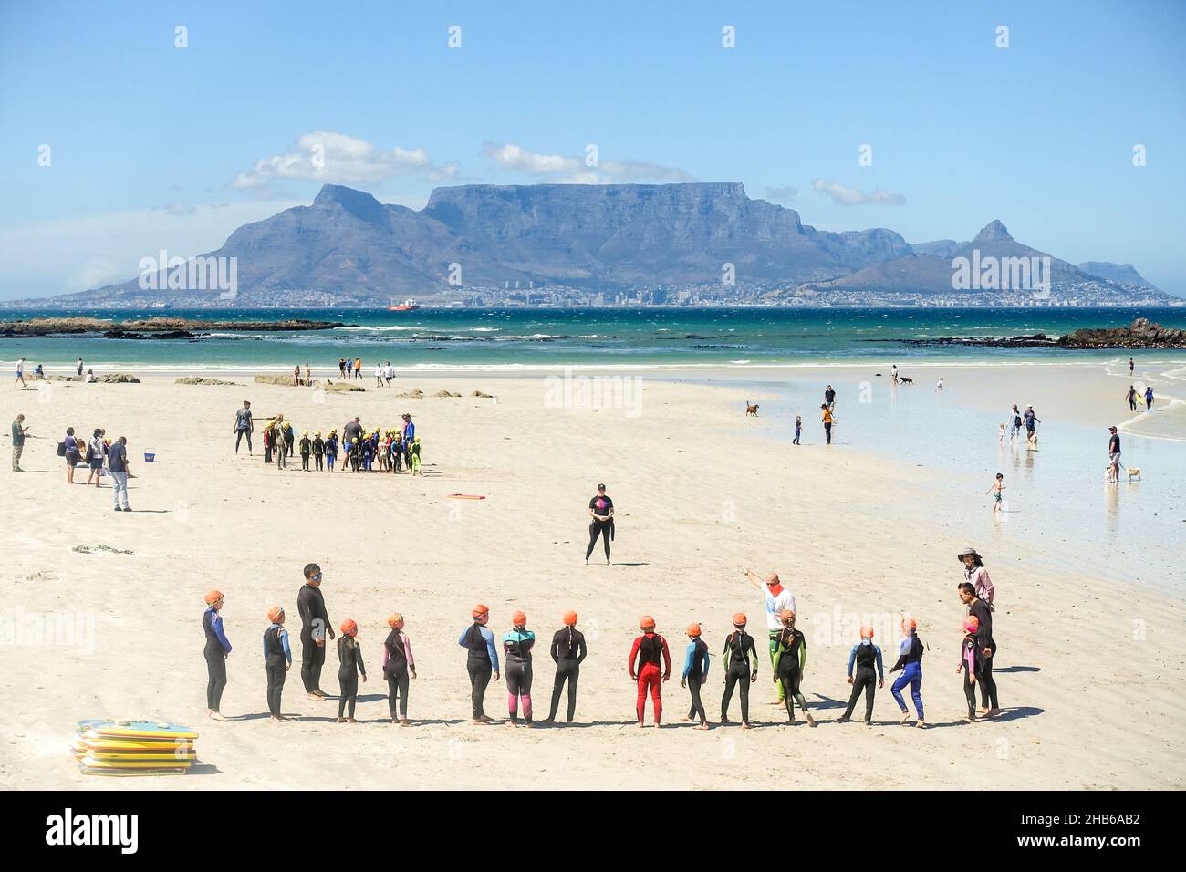Los niños aprenden a hacer surf en la playa de Big Bay, Ciudad del Cabo, Sudáfrica Foto de stock