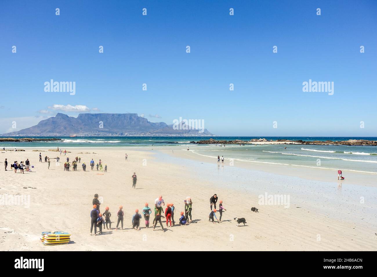 Los niños aprenden a hacer surf en la playa de Big Bay, Ciudad del Cabo, Sudáfrica Foto de stock