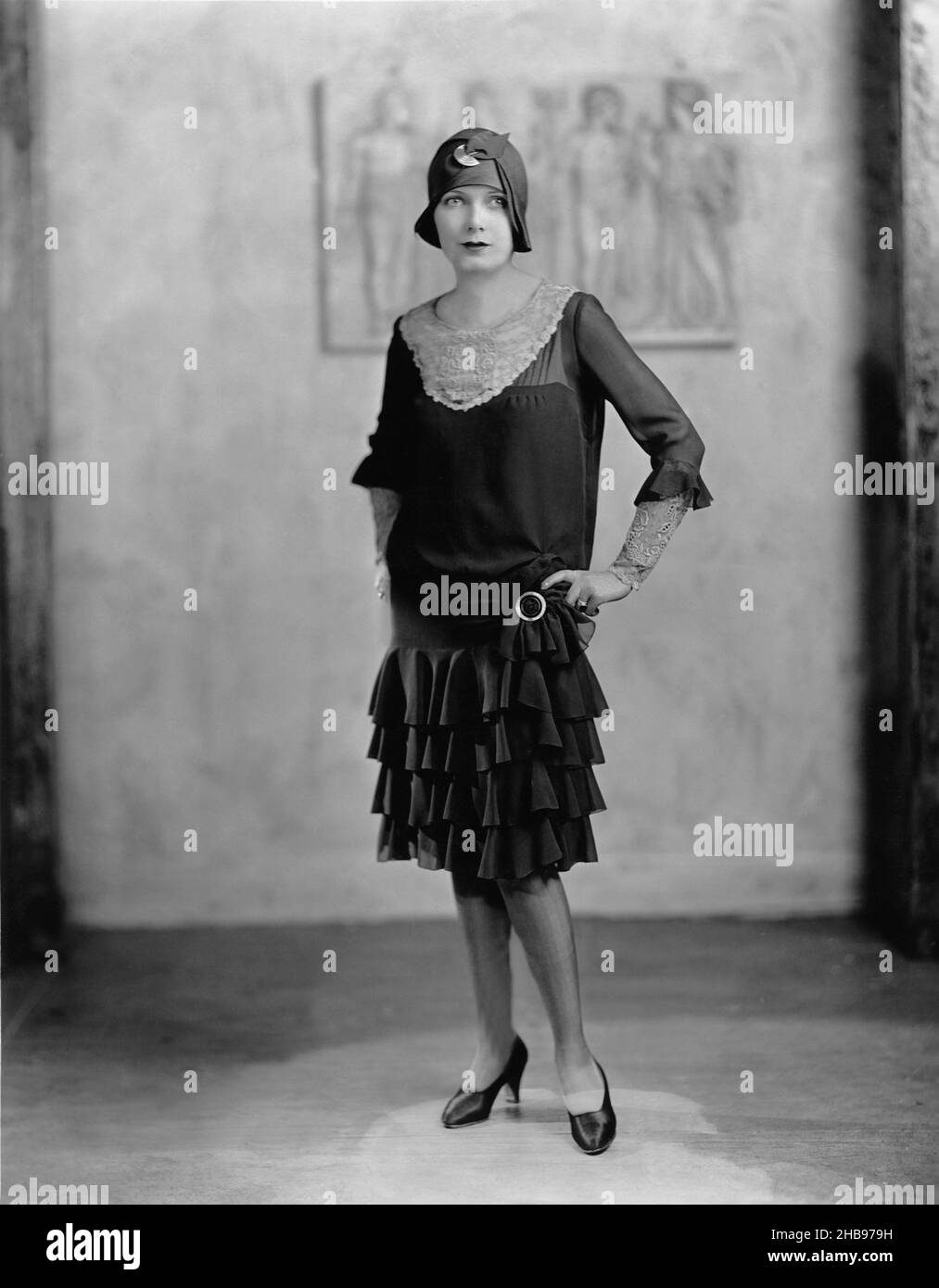 Mujer joven en un vestido 'flapper' y sombrero de cloche posando para  retrato con las manos en las caderas. Alrededor de 1922 Fotografía de stock  - Alamy