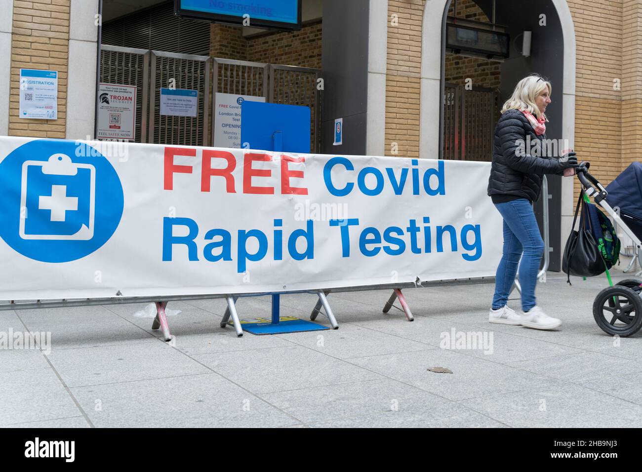 Una mujer entra con un cochecito en el sitio de pruebas Rapid COVID-19 de Londres, Inglaterra, Reino Unido Foto de stock