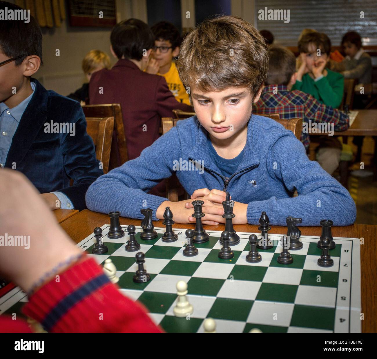 Juegos inteligentes. Un niño juega al ajedrez. Niño y un tablero de ajedrez. Estrategia. Pensamiento lógico. Foto de stock