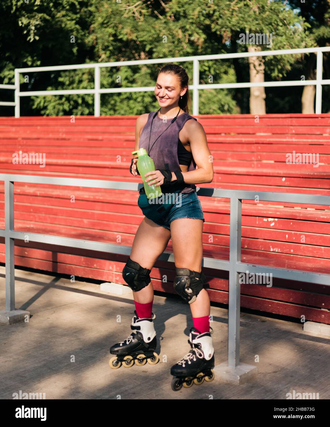 Mujer alegre con ropa deportiva y patines posando en el parque de patinaje.  El concepto de actividades al aire libre. Hobby. Estilo de vida deportivo  Fotografía de stock - Alamy