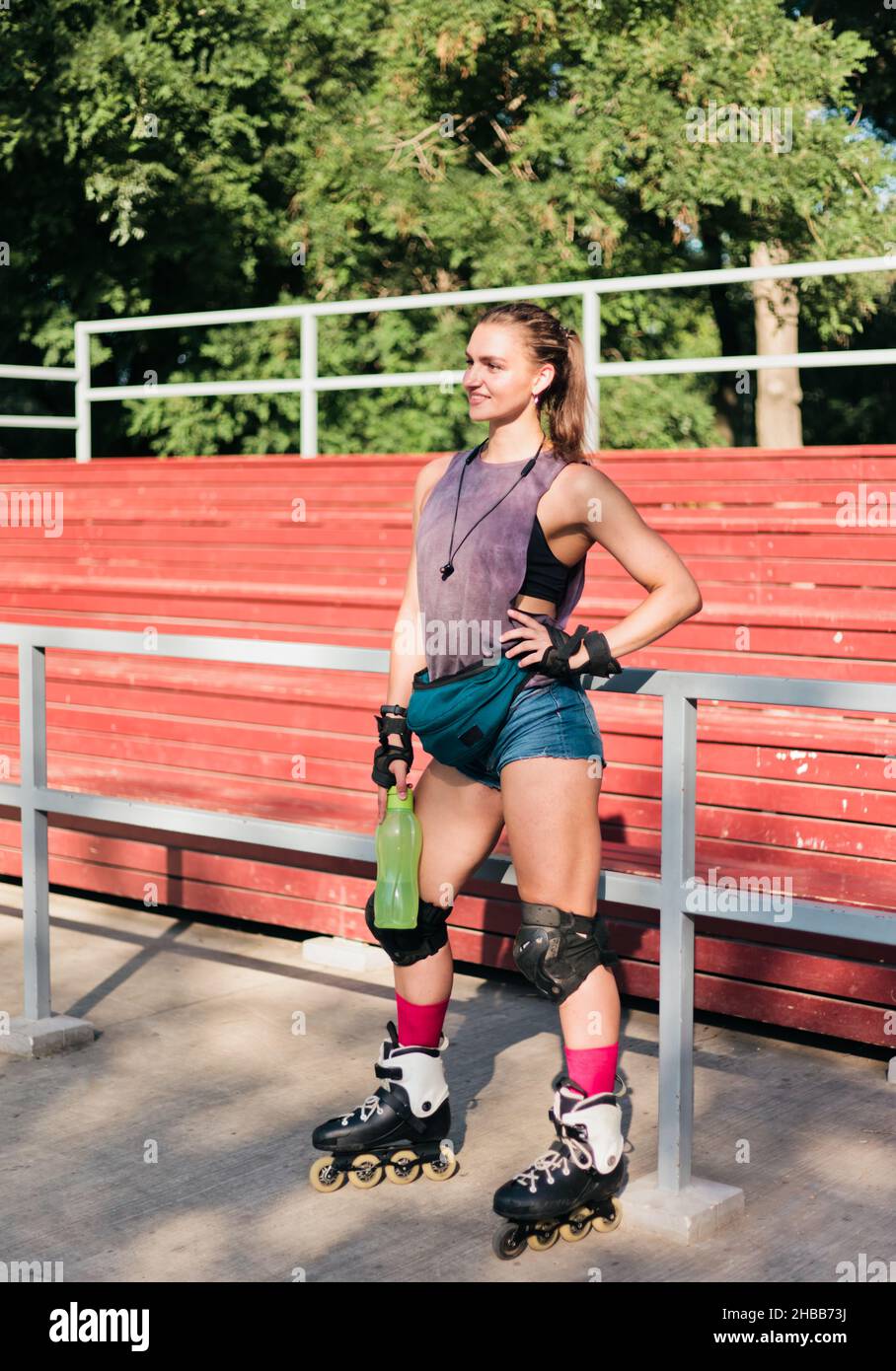 Mujer alegre con ropa deportiva y patines posando en el parque de patinaje.  El concepto de actividades al aire libre. Hobby. Estilo de vida deportivo  Fotografía de stock - Alamy