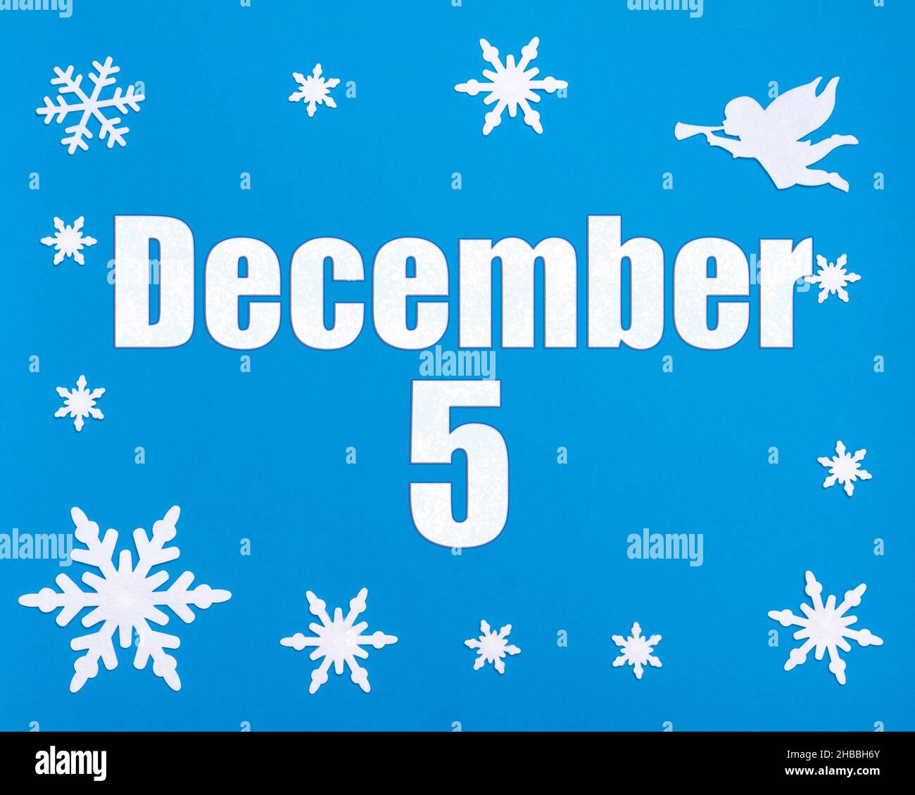 5th de diciembre. Fondo azul de invierno con copos de nieve, ángel y una fecha calendario. Día 5 del mes. Concepto de mes de invierno, día del año. Foto de stock