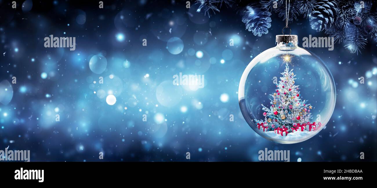 Árbol de Navidad en rama de Abeto Colgante Bauble con cajas de regalo en Noche Abstracta Azul Foto de stock