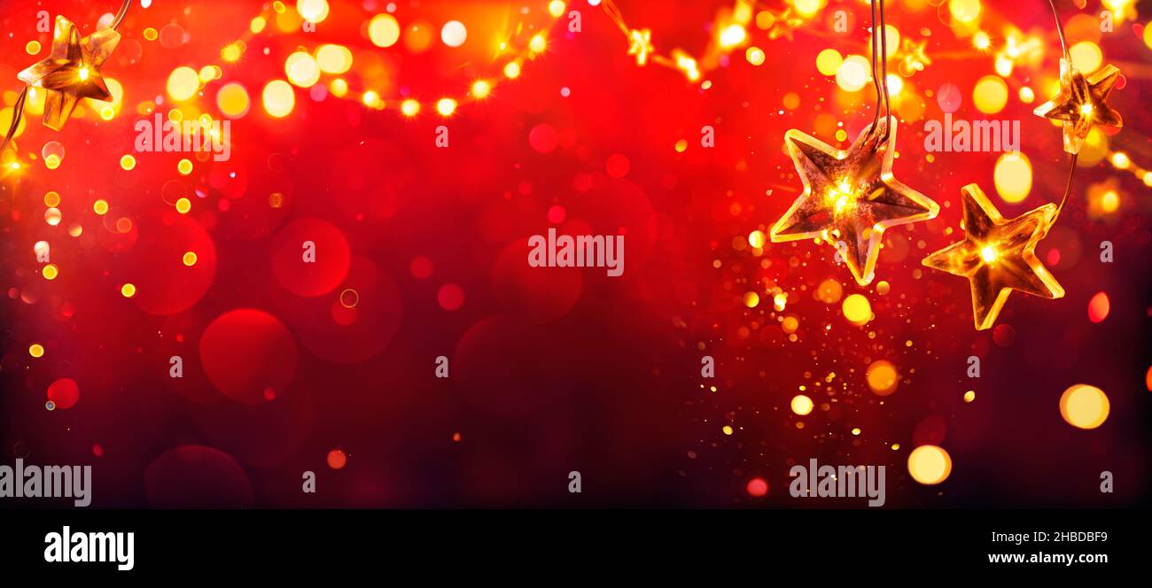 Navidad roja - Luces de las estrellas doradas con brillos desfocados abstractos Foto de stock