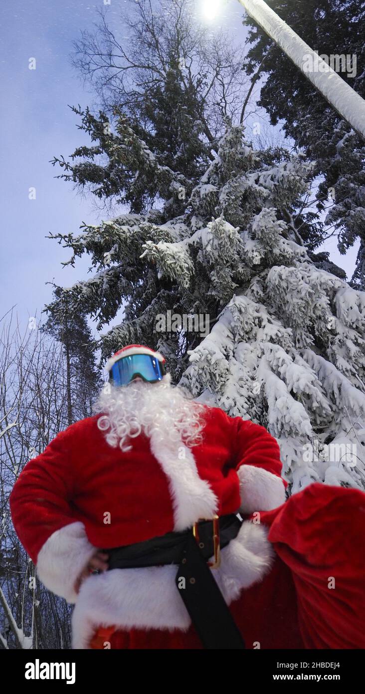 Retrato de Santa Claus en gafas de esquí en el bosque de invierno. Navidad. Foto de stock