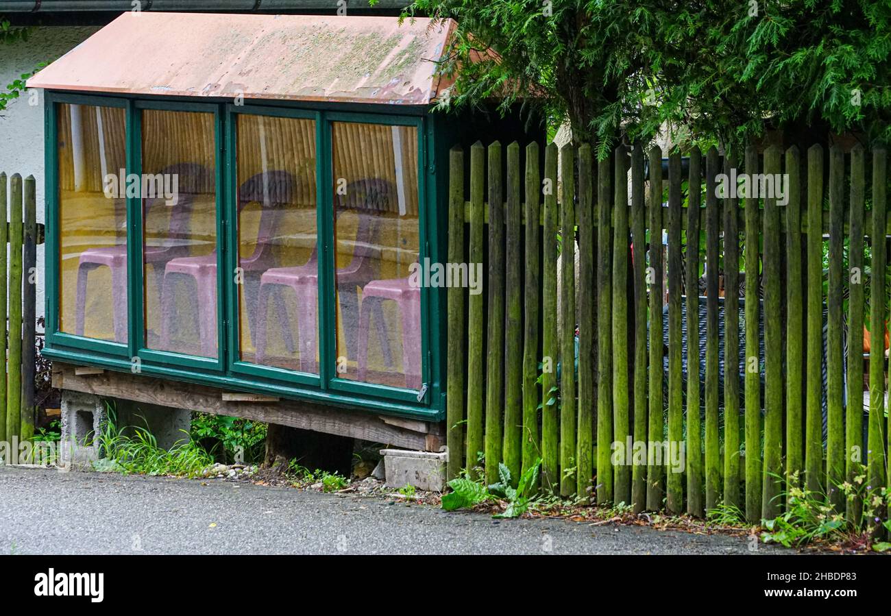 Un comerciante hizo una broma y puso cuatro sillas de jardín púrpura en su escaparate separado. Foto de stock