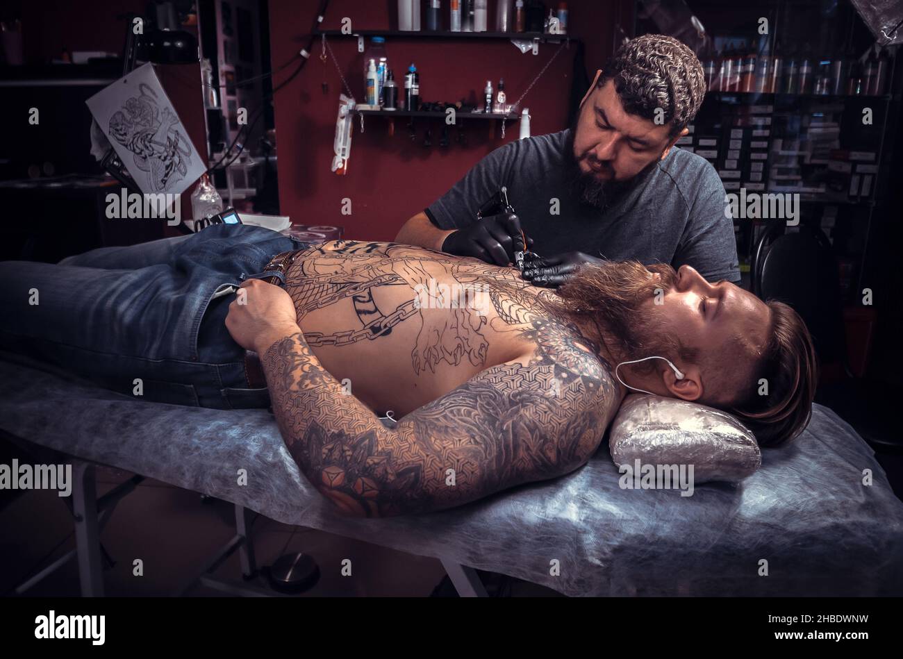 Maestro del arte del tatuaje durante un salón de sesiones de tatuaje Foto de stock