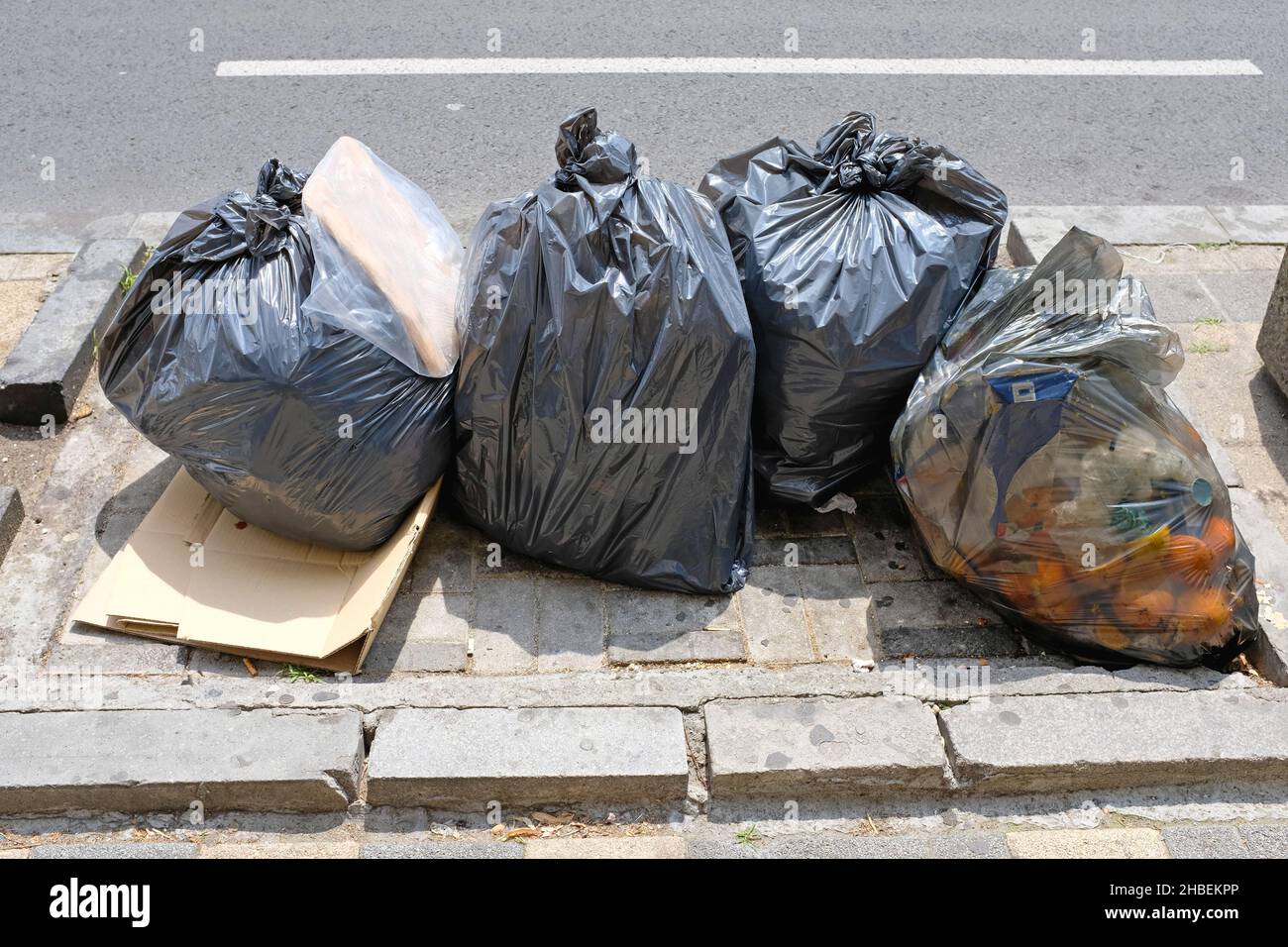 Muchas bolsas negras grandes de la basura en la basura de la calle  Fotografía de stock - Alamy