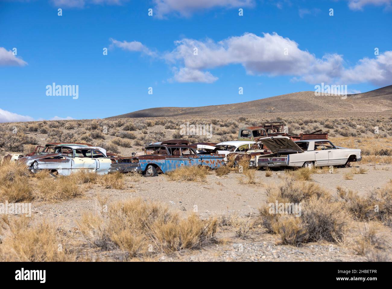El grupo de junkyard de viejos carros oxidados abandonados se sienta en el desierto podrido lejos Foto de stock