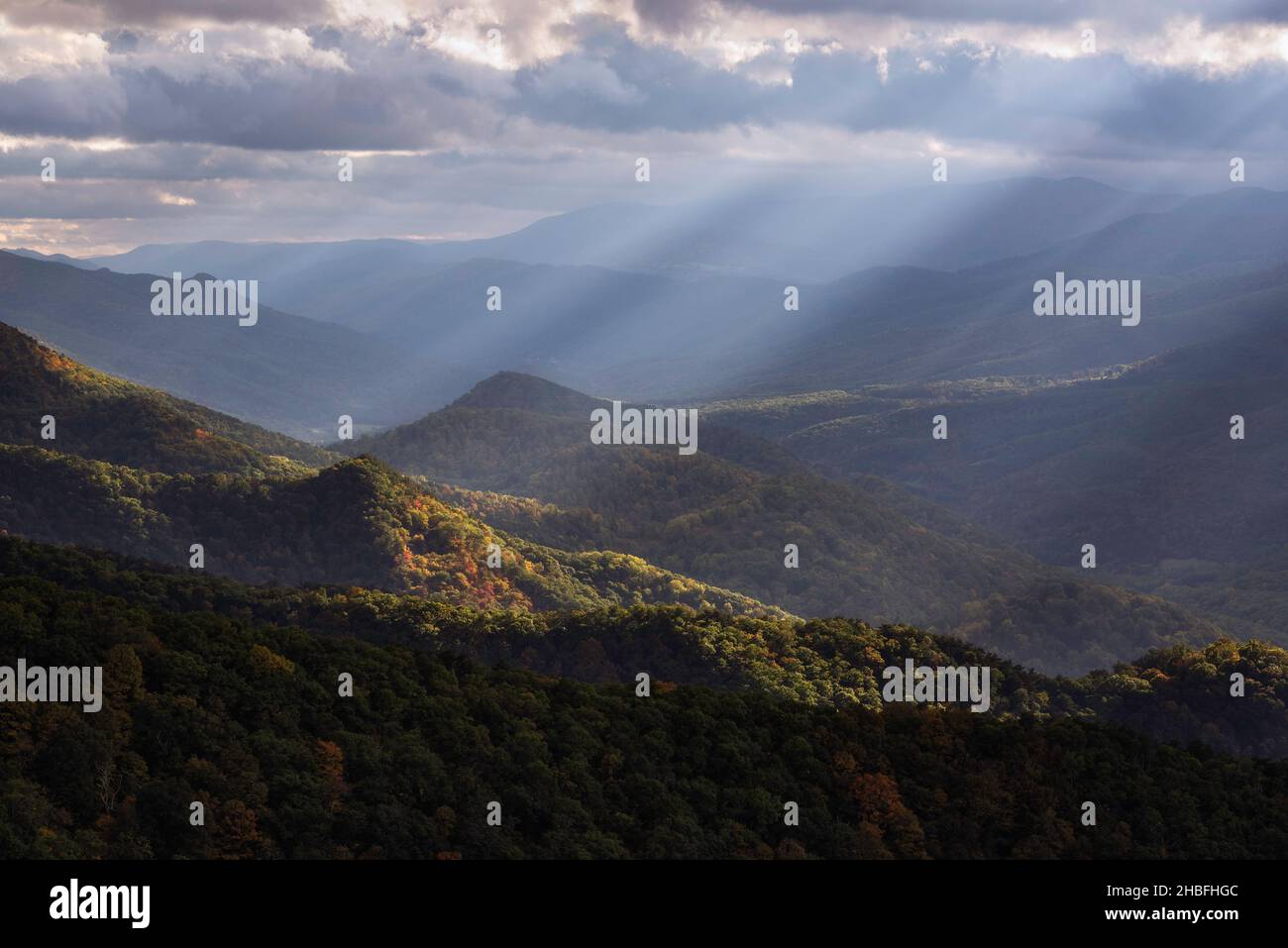 Rayos de luz crepusculares que brillan a través del Valle de North Fork en Virginia Occidental, iluminando algunos de los principios del otoño de color abajo. Foto de stock