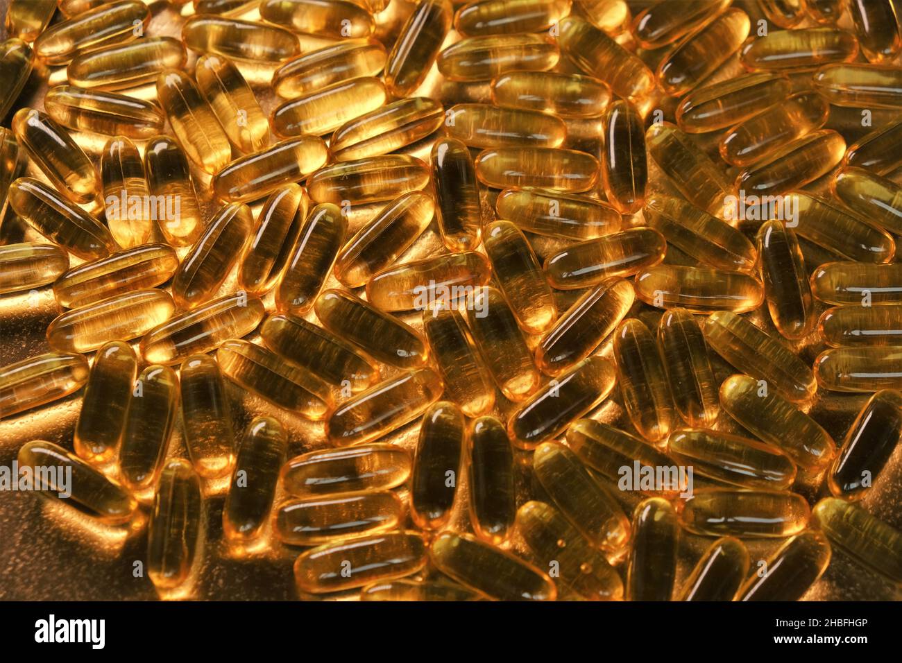 ácidos grasos omega.Suplementos naturales y vitamina.Cápsulas de aceite de pescado fondo de oro. Foto de stock