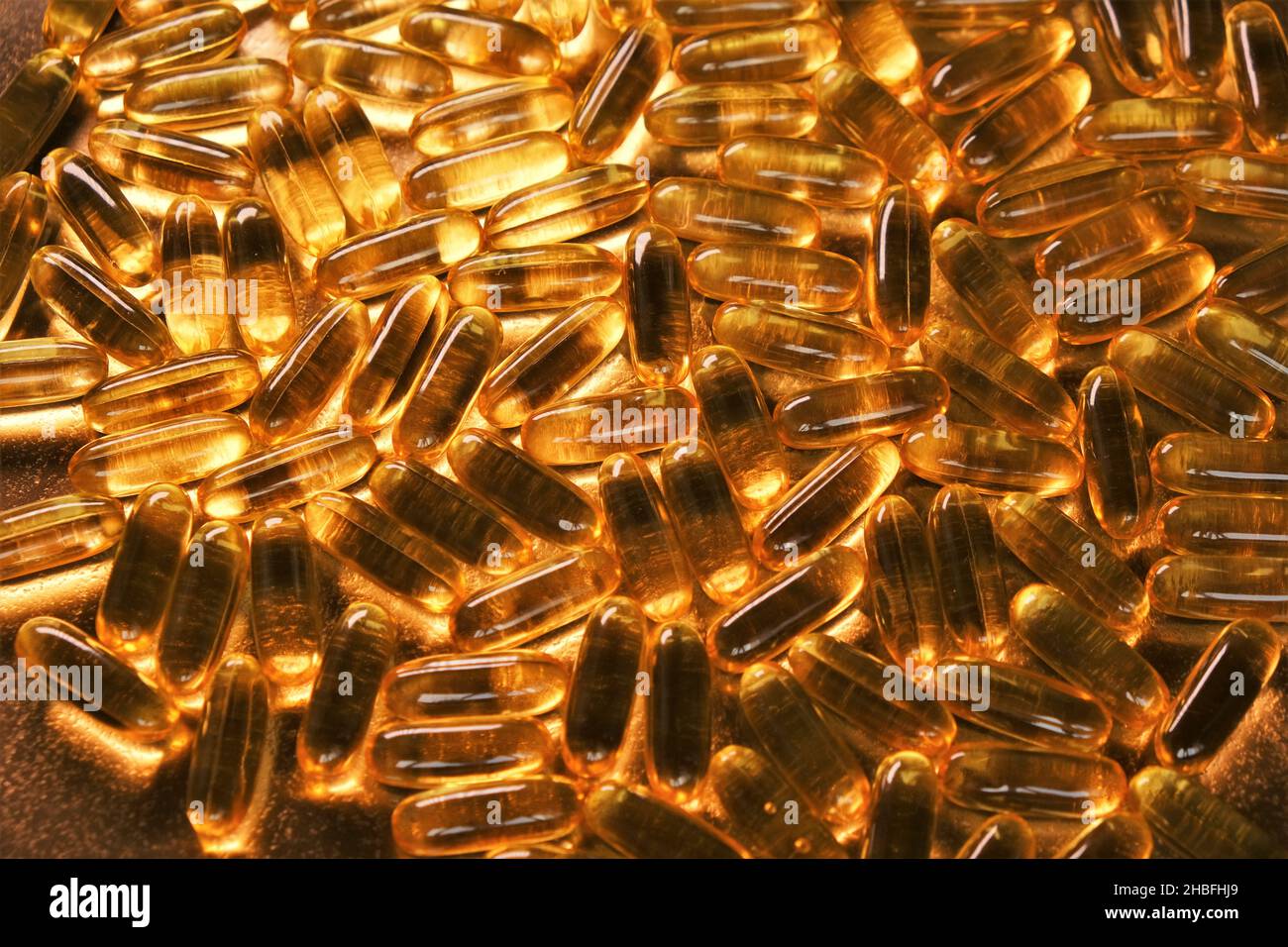 Aceite de Pescado Cápsulas de oro fondo. ácidos grasos omega. Suplementos naturales y vitamina. Foto de stock