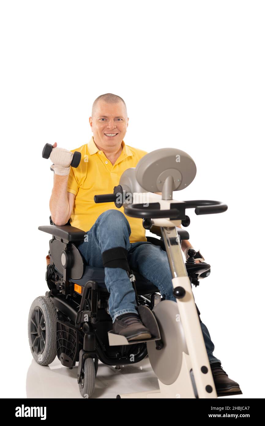 El hombre discapacitado tiene ejercicios de rehabilitación para las piernas. Motocicleta para piernas y manos. Aislado sobre fondo blanco Foto de stock