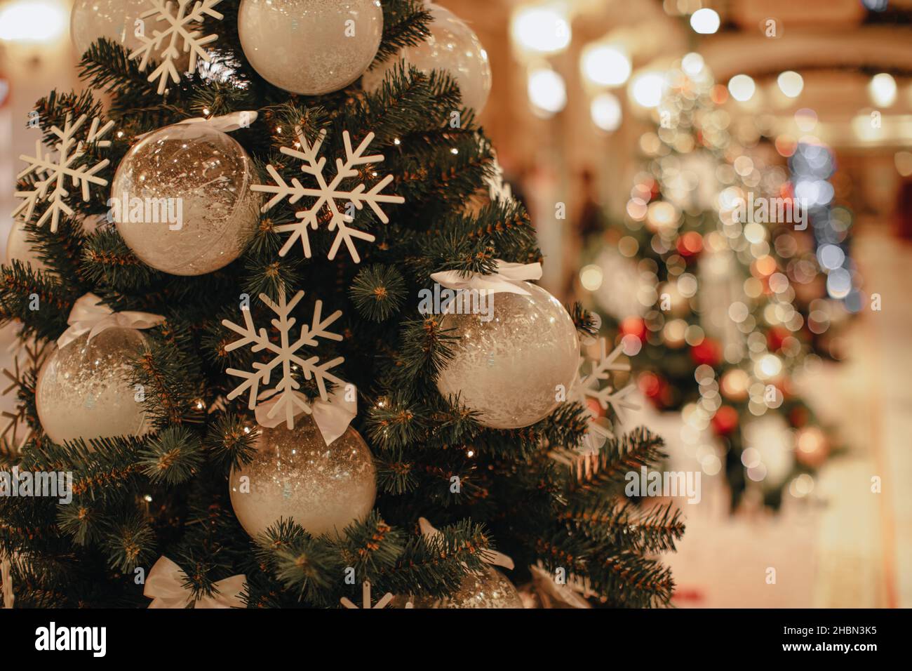 Ramas verdes del árbol de Navidad decoradas con copos de nieve blancos y  bolas navideñas festivas nevadas. Año nuevo temporada de invierno.  Decoración interior Fotografía de stock - Alamy