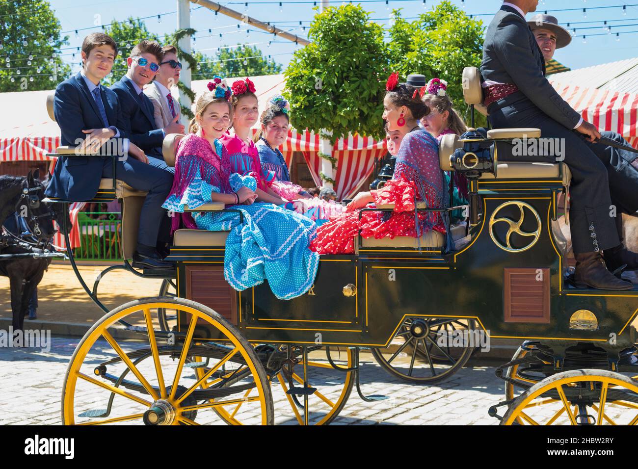 Sevilla, provincia de Sevilla, Andalucía, sur de España. Feria de Abril. Desfile de caballos y carruajes. Jóvenes amantes de la feria sonriendo a la cámara Foto de stock