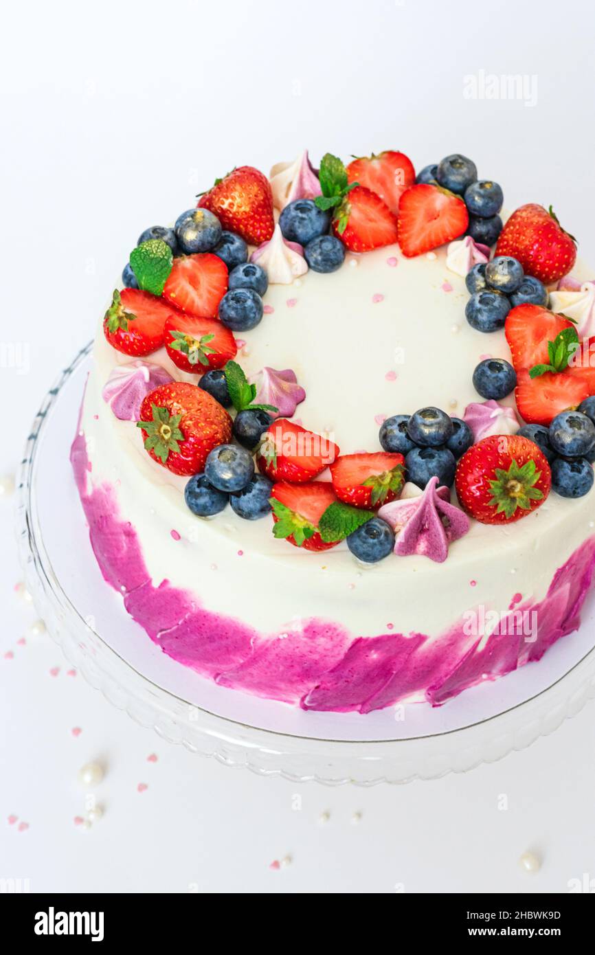 Delicado pastel decorado con bayas frescas fresas arándanos blanco fondo  liso. Postre festivo con bayas Fotografía de stock - Alamy