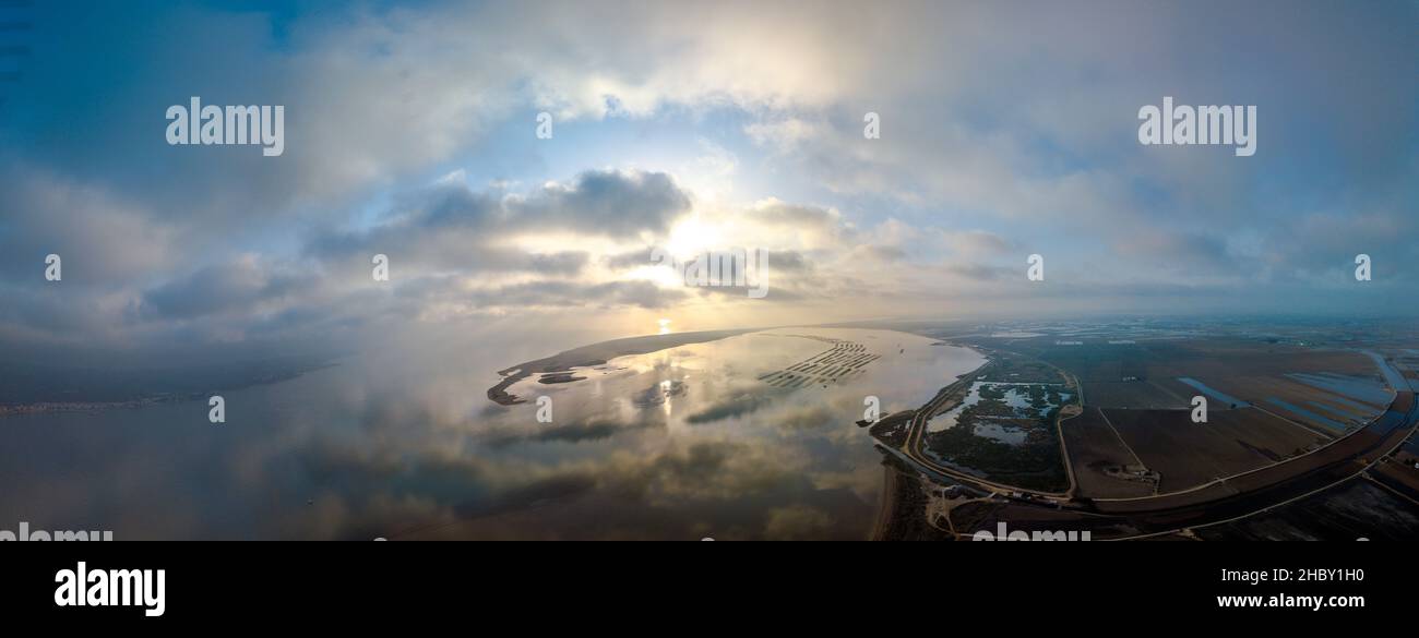 Toma panorámica aérea de un cuerpo de agua que refleja el atardecer panorámico o las nubes del amanecer Foto de stock