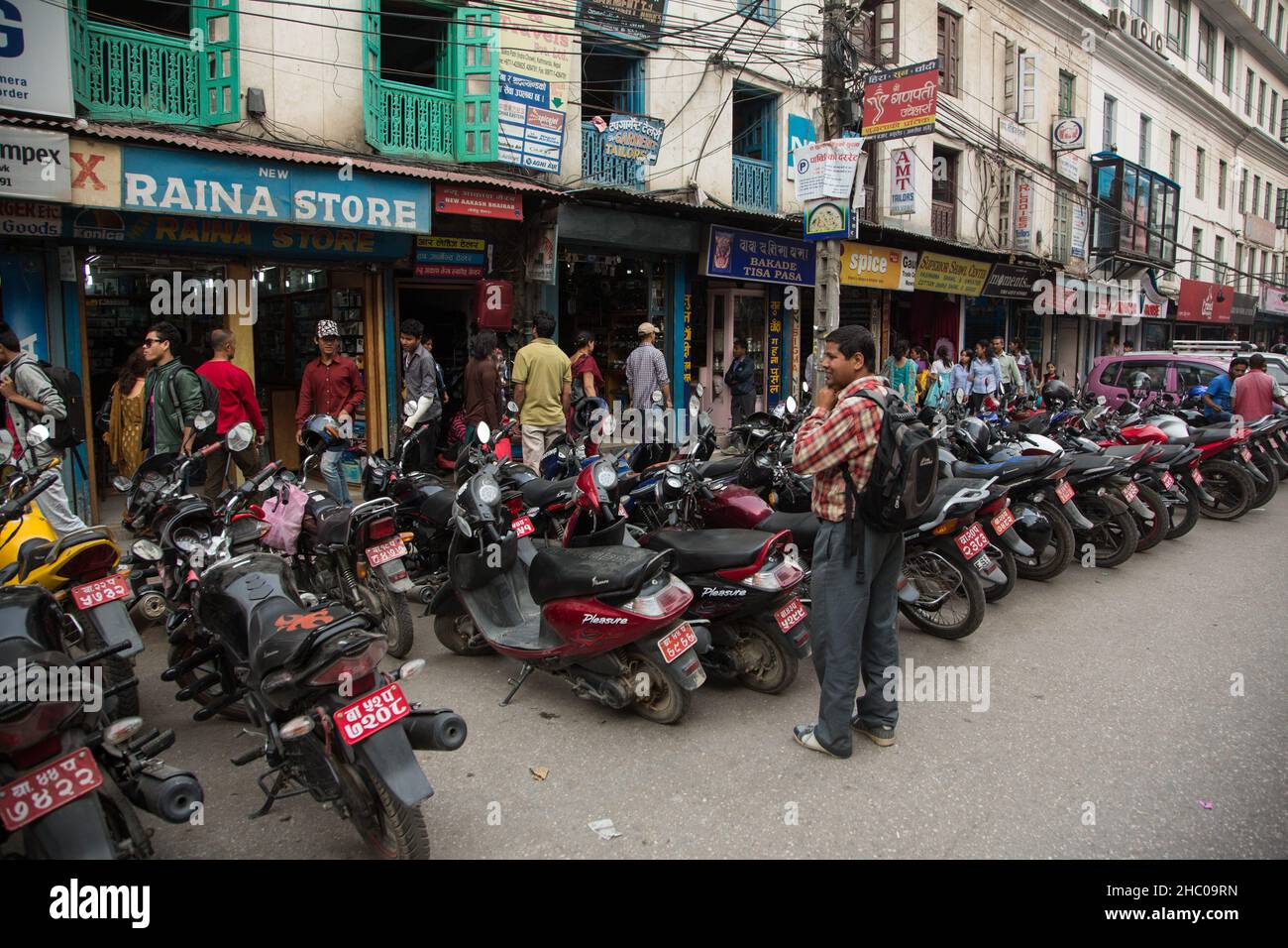 Una doble fila de motocicletas estacionadas en una calle en un distrito comercial en Katmandú, Nepal. Foto de stock