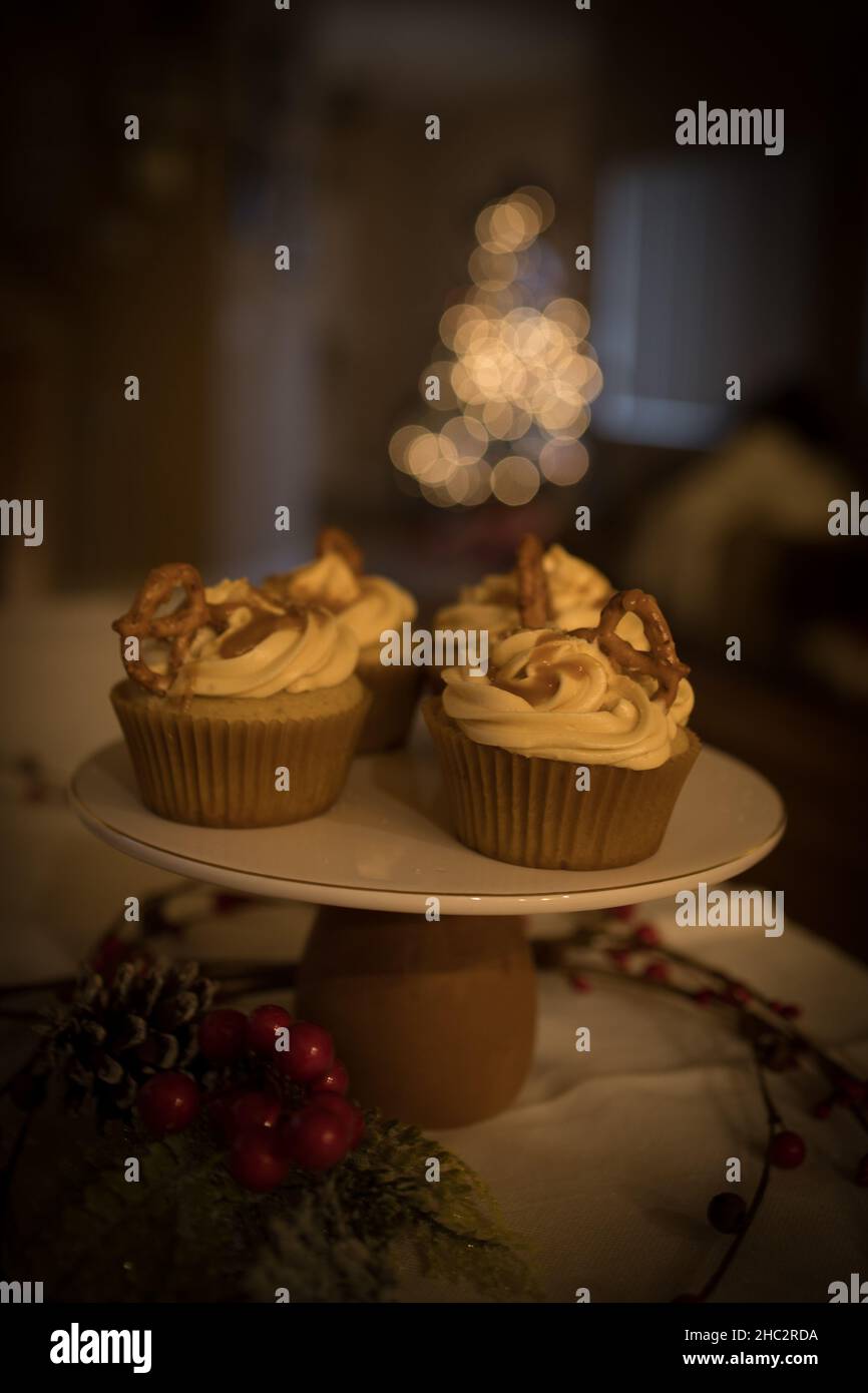 Pastelitos de caramelo, luces de árbol de Navidad en el fondo, decoraciones de invierno, puesto de pastel Foto de stock