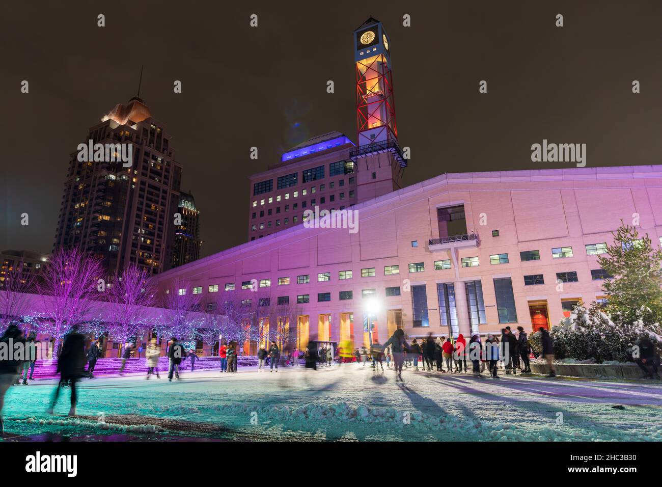 Las personas que patinan en el Mississauga City Hall Celebration Square Ice Skating Rink en la noche de invierno durante el período de la pandemia de Covid-19. Foto de stock