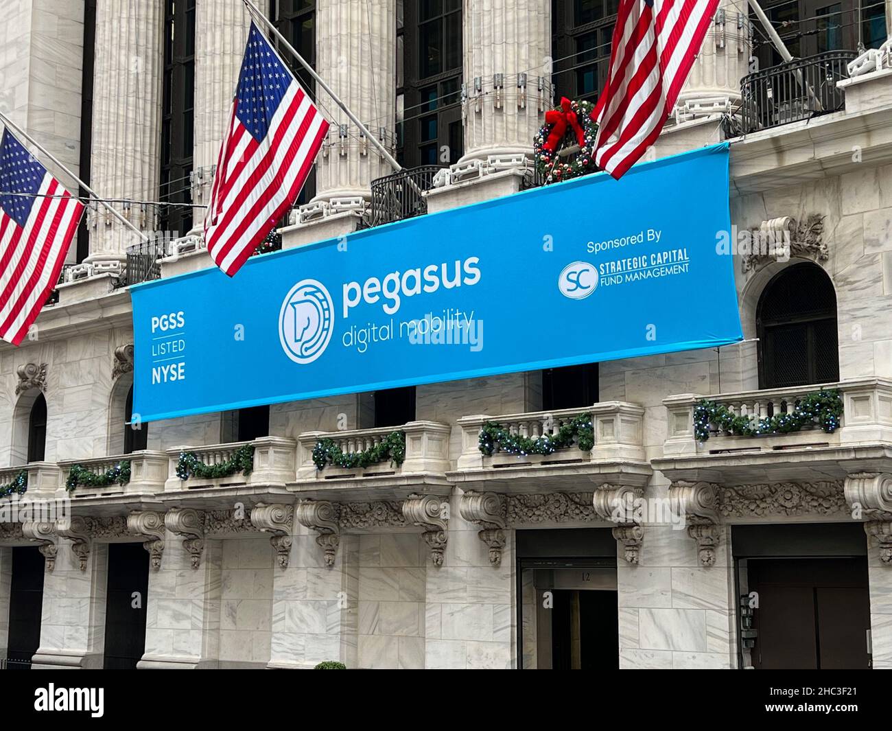 Nueva York, Estados Unidos. 23rd de Dic de 2021. Un banner con el logotipo de Pegasus Digital Mobility Acquisition Corp. Y el símbolo de ticker cuelga de la Bolsa de Nueva York en Broad Street en el Bajo Manhattan el 23 de diciembre de 2021. La compañía de cheques en blanco cotiza recientemente en la Bolsa de Nueva York bajo el símbolo del ticker PGSS. (Foto de Samuel Rigelhaupt/Sipa USA ) Crédito: SIPA US/Alamy Live News Foto de stock