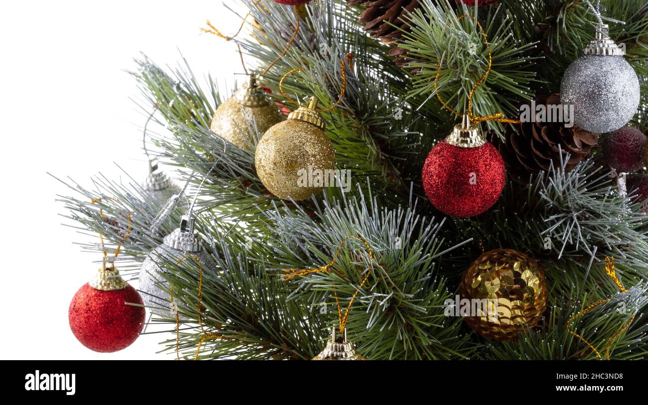 Árbol de Navidad. Ramas de pino verde decoradas con bolas de color rojo  brillante, dorado, plateado, conos y bayas rojas. Puntas de ramas de pino  cubiertas de nieve. ISO Fotografía de stock -