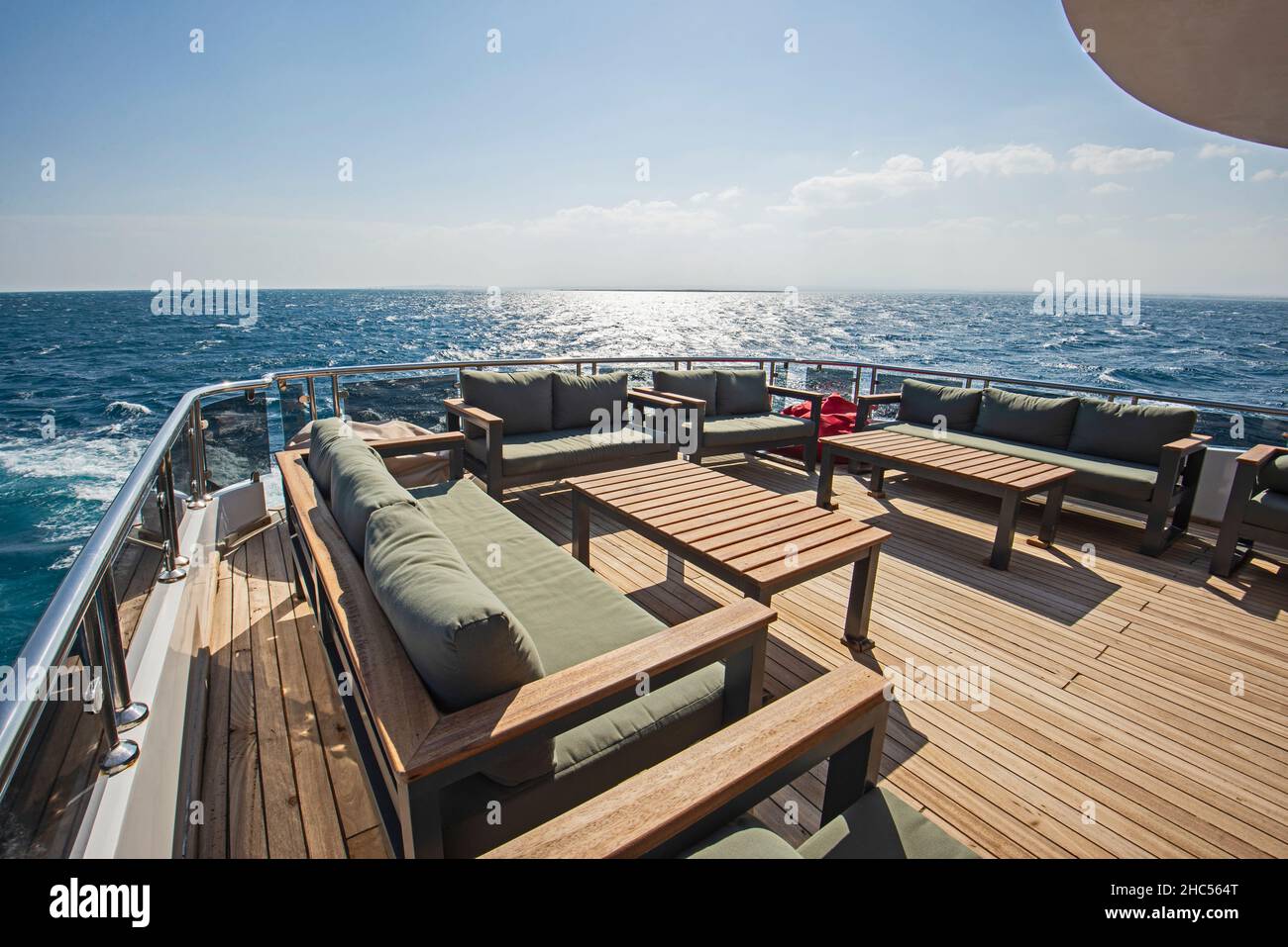Cubierta de madera de teca de popa de un gran yate de lujo a motor con  sillas sofá-mesa y fondo tropical con vistas al mar Fotografía de stock -  Alamy
