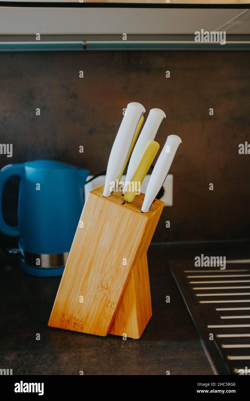 Disparo vertical de un cuchillo de cocina en un soporte de madera Foto de stock