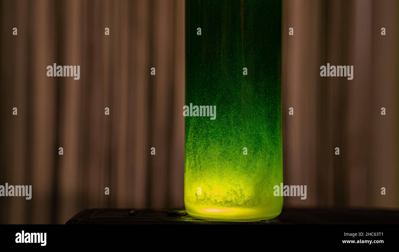 Cristal con líquido verde iluminado con luz amarilla Foto de stock