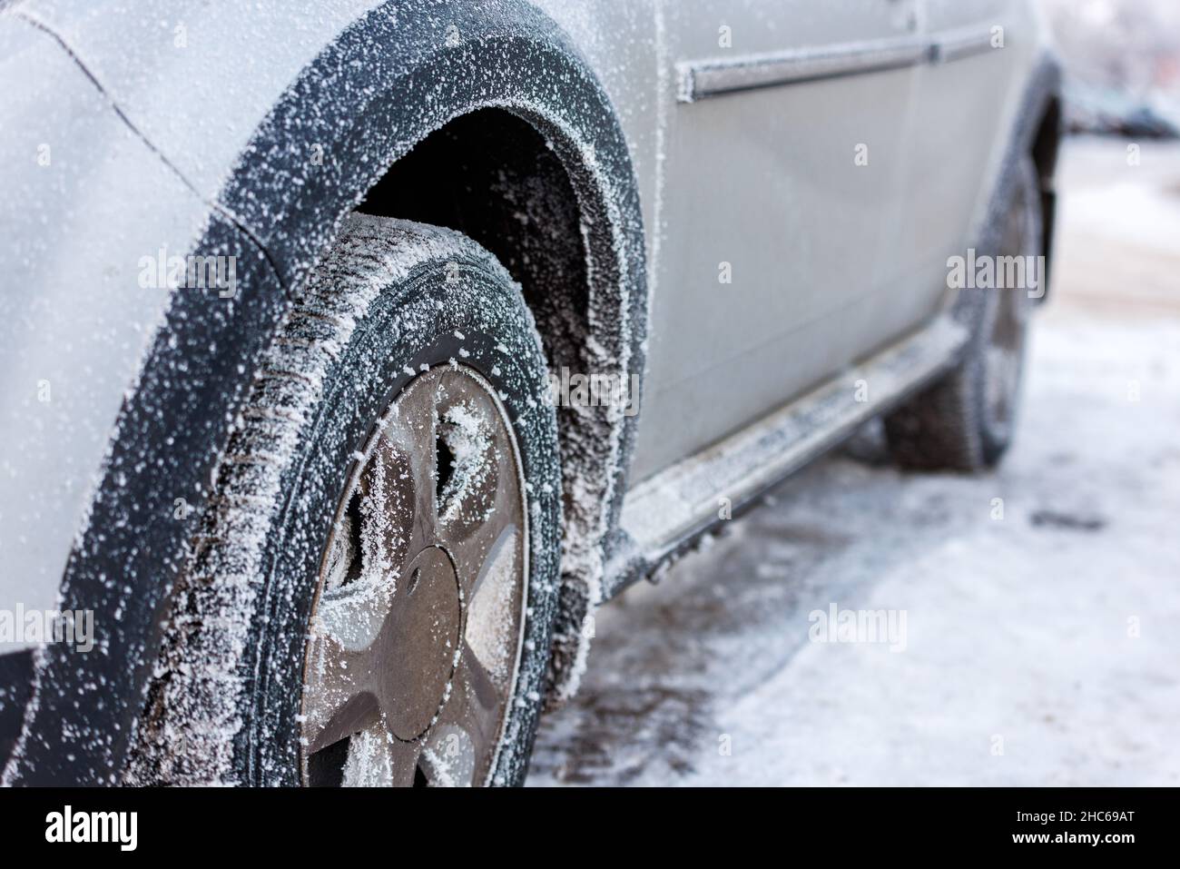 rueda de coche cubierta de la helada en mañana fría del invierno Foto de stock